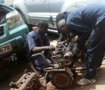 Mechanics servicing an engine
